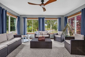 A sunroom with wicker furniture, large windows, and a ceiling fan. - Biscayne Ln Retreat/Pool, Game Room & Wawasee Fun (Cromwell)
