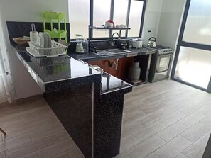 A modern kitchen with a granite countertop, a built-in oven, and a window providing natural light.