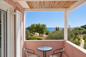 Ein Balkon mit Meerblick, einem Tisch und zwei Stühlen.