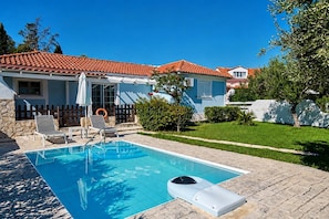 A residential property with a swimming pool, a fenced backyard, and a house with a red-tiled roof. - Villa Thalia Galini - Two Bedroom Villa, Sleeps 4 (Vassilikos)