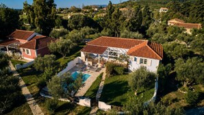 Un quartier résidentiel avec des maisons, une piscine et un paysage vallonné.