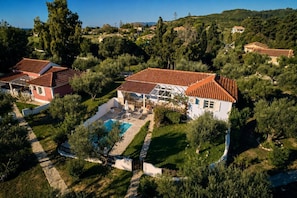 A residential area with houses, a swimming pool, and a hilly landscape. - Villa Thalia Galini - Two Bedroom Villa, Sleeps 4 (Vassilikos)