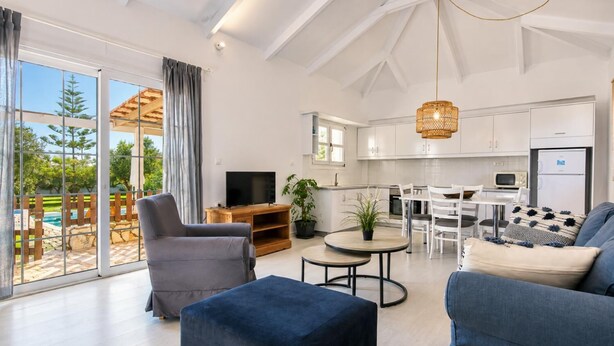 Un salon moderne avec un téléviseur, un canapé et un coin repas.