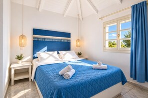 A hotel room with a bed, bedside tables, a window with curtains, and a view of greenery outside. - Villa Thalia Galini - Two Bedroom Villa, Sleeps 4 (Vassilikos)