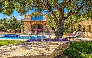A stone house with a swimming pool, outdoor seating, and a large tree. - Villa Tireda Tria - Three Bedroom Villa, Sleeps 6 (Koridallos)