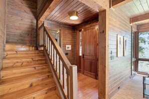 A wooden staircase leading to a door with a stone wall behind it. - Highlands Mountain Meadow -Luxury 4/3.5 cabin-Mins to Highlands-Views- Hot Tub (Scaly Mountain)