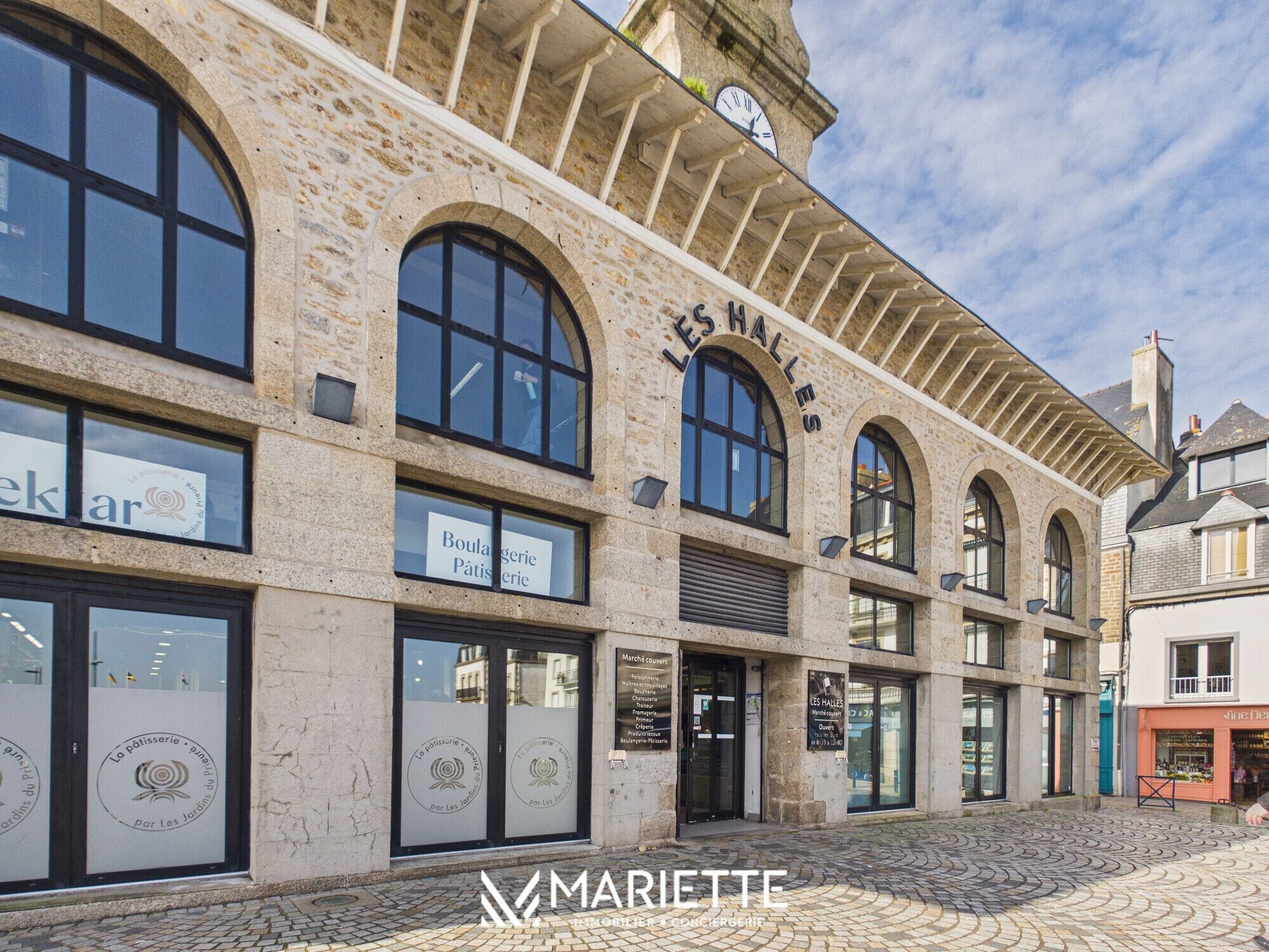 Un bâtiment historique doté de fenêtres en arc de cercle et d’une tour horloge.