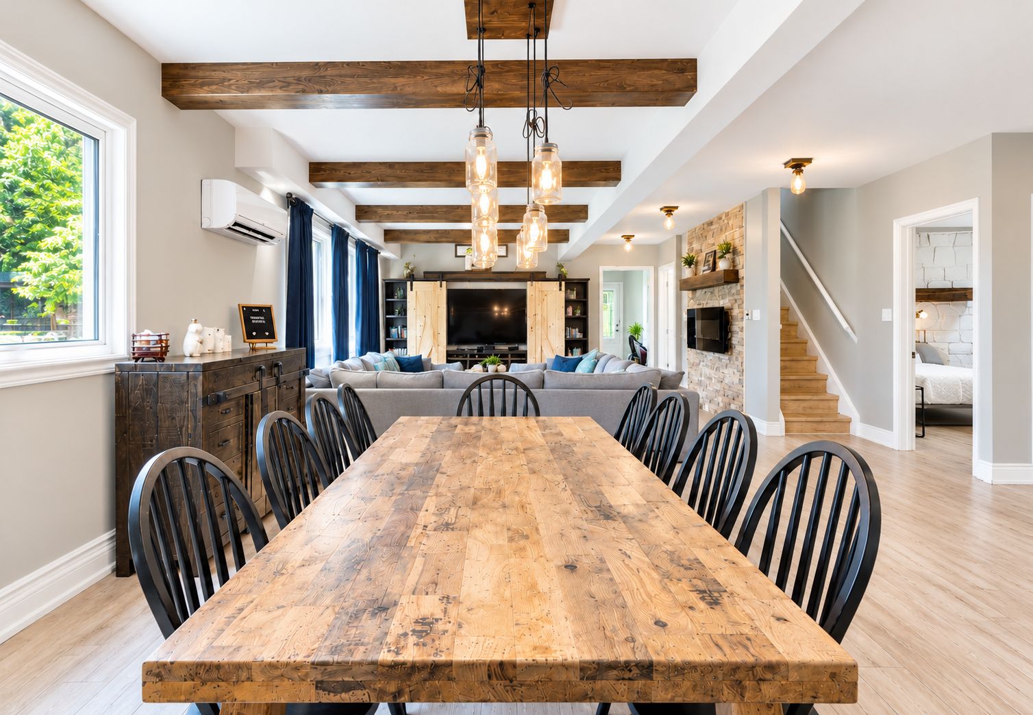A dining area with a wooden table and chairs, a kitchen with a built-in oven, and a living room with a sofa and TV.