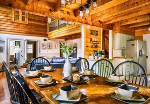 A wooden interior with a dining area, kitchen, and living space. - Rustic Cabin with Fire Pit and Hot Tub (Pigeon Forge)