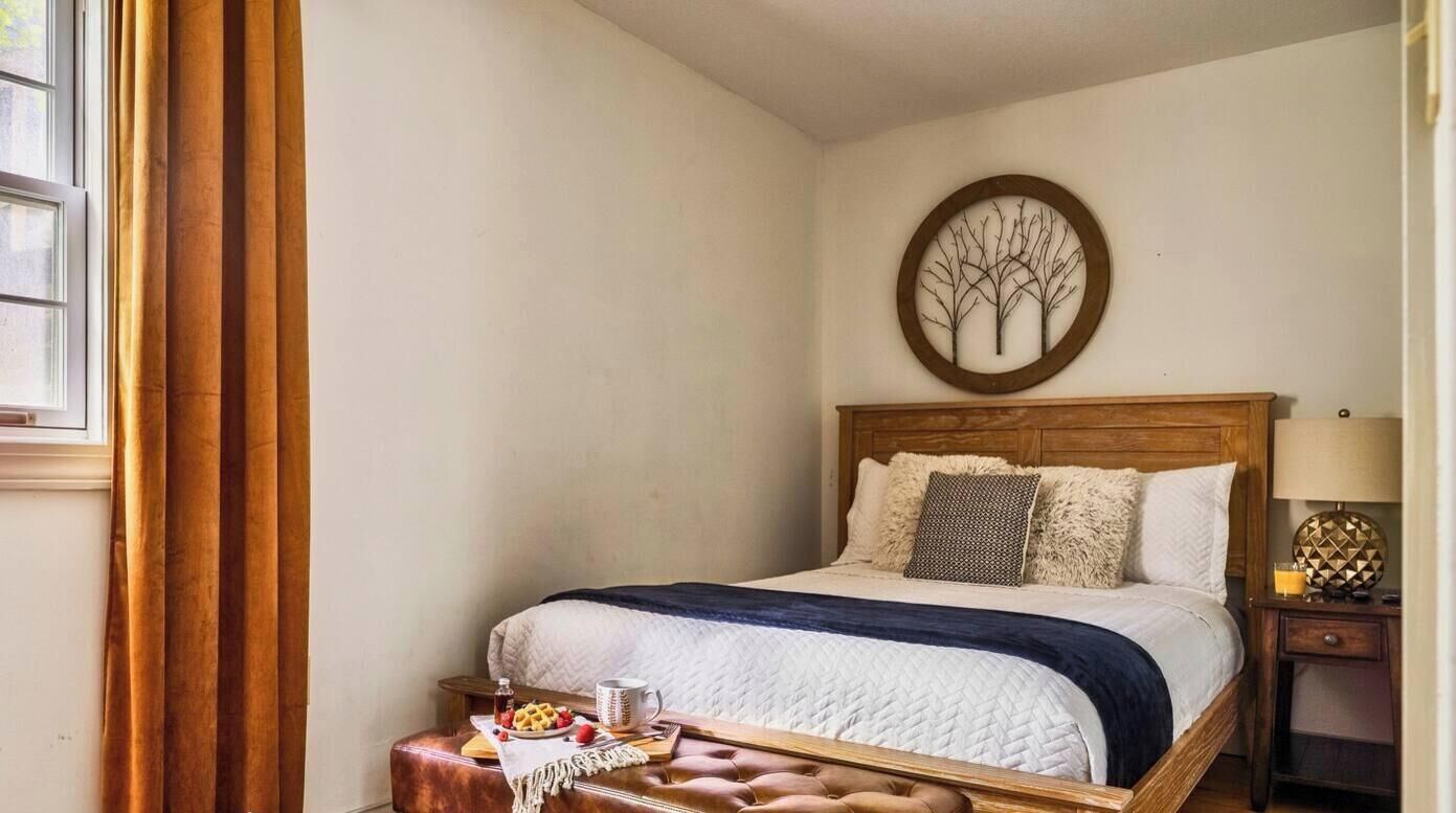 Une chambre à coucher comprenant un lit, une table de chevet, une lampe et un élément décoratif mural.