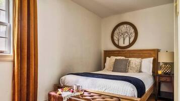 Une chambre à coucher comprenant un lit, une table de chevet, une lampe et un élément décoratif mural.