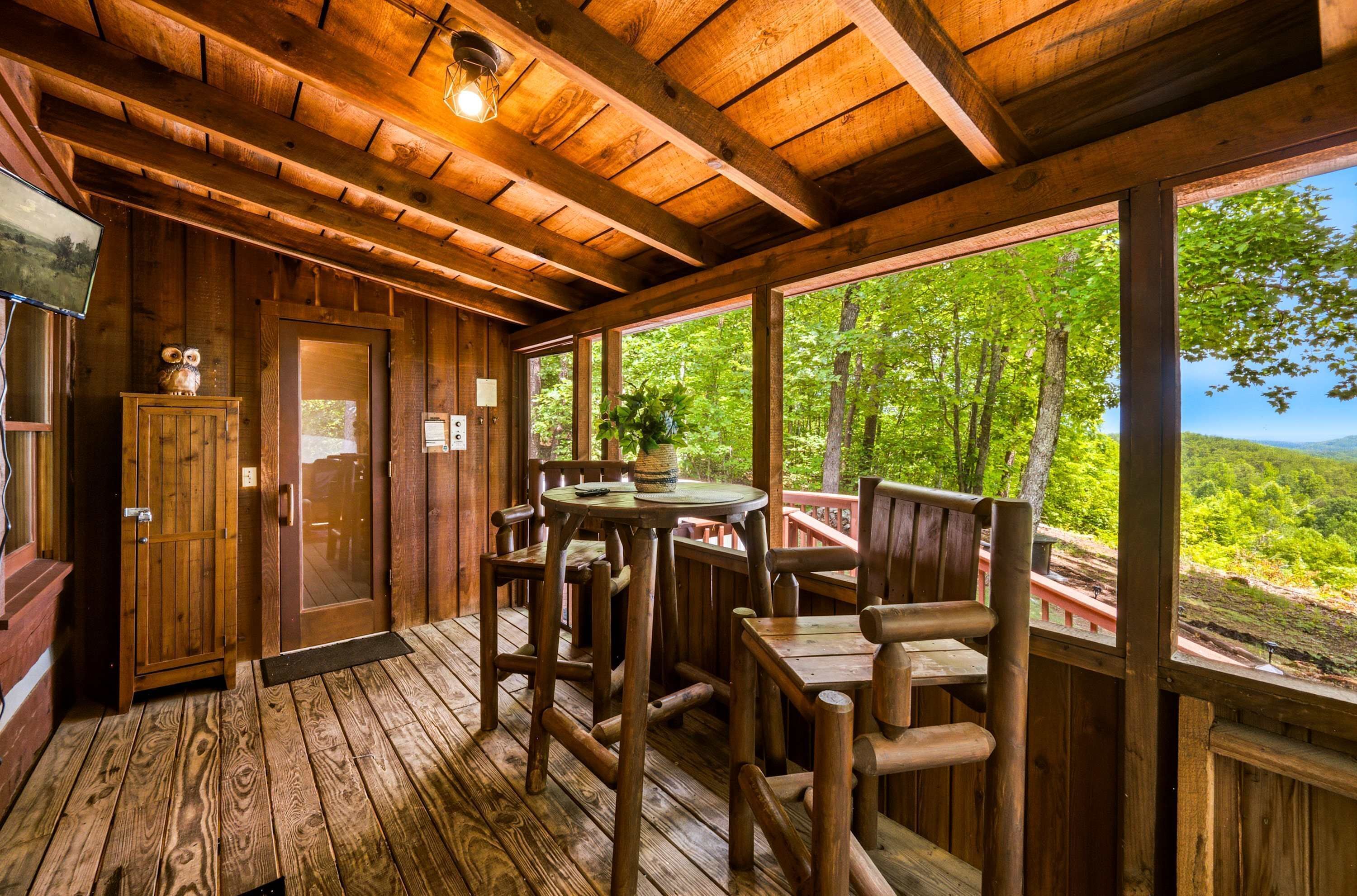 A wooden cabin with a deck, a dining table, and chairs.