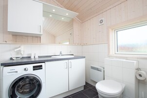 Ein modernes Badezimmer mit Waschmaschine, Waschbecken und Toilette.
