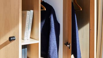 Een houten garderobe met verschillende planken, een kledingroede en een spiegel.