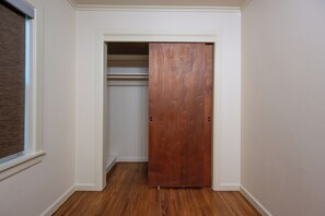 Ein Flur mit einer Holztür, die zu einem Schrank mit einer weißen Tür führt.
