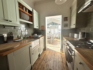 A kitchen with wooden countertops, a stove, and a view to an outdoor patio. - Shipside Village Location
Calm & relaxing Eastbourne apartment & private garden (Eastbourne)