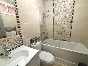 Ein Badezimmer mit Badewanne, Toilette und Waschbecken.