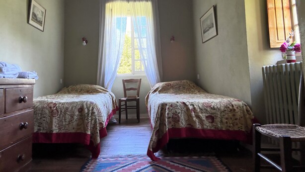 A room with two beds, a chair, a dresser, and a radiator. - The tranquility of rural France!  A charming cottage attached to an old farmhouse. (Uzech)
