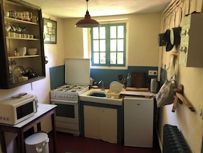 A compact kitchen with a stove, sink, and microwave.