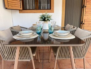 A dining table set with plates, glasses, and a vase of flowers. - Ibizan-Style House in Benicasim · 3 minutes from the beach · Pool and parking (Benicàssim)