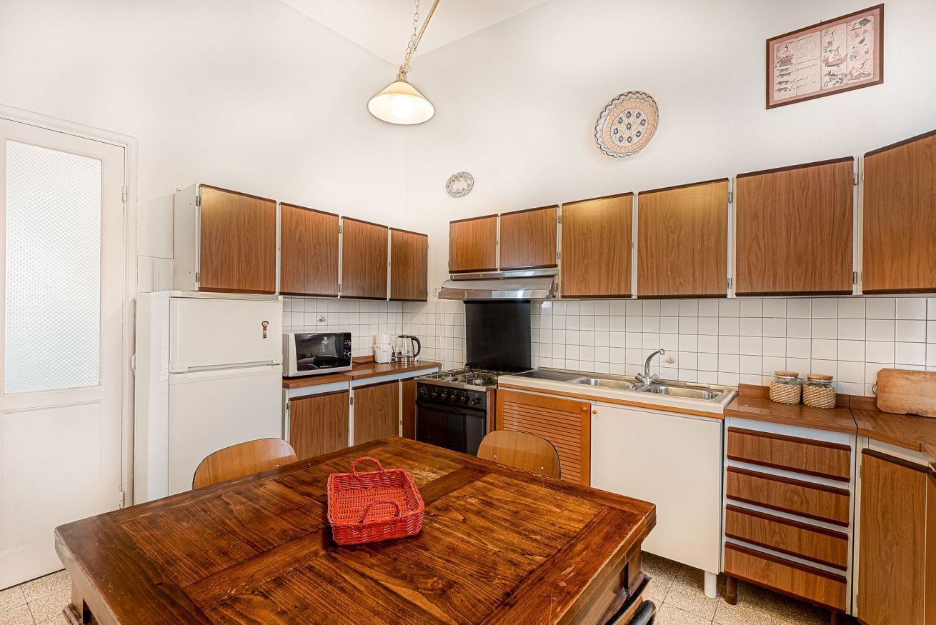 Une cuisine avec des meubles de rangement en bois, un réfrigérateur blanc, une cuisinière et un évier.