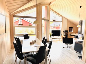 Ein modernes Interieur mit Essbereich, Fernseher und Küchenzeile.