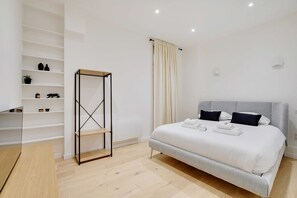 A modern bedroom with a bed, a wardrobe, and a shelf unit. - Cosy Modern Flat 1BR 4P Oberkampf (Paris)