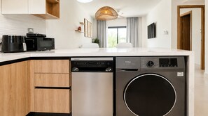A modern kitchen with a dishwasher, a built-in oven, and a washing machine. - Born | 2Bed Pool View | Up to 6 Guests (Bavaro)