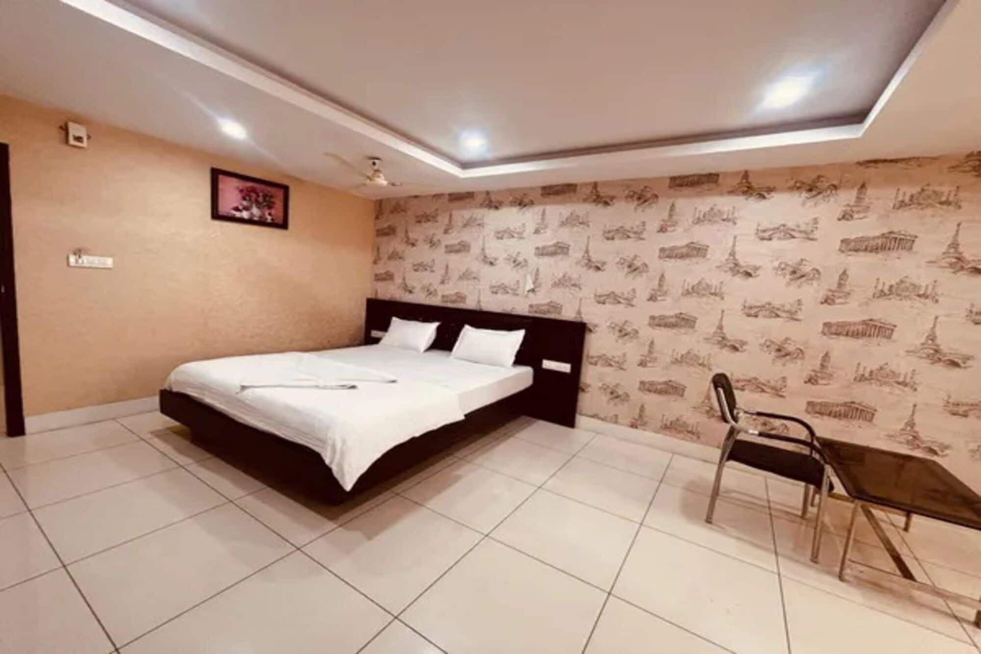 Un dormitorio con una cama, una silla y un muro con diseño.