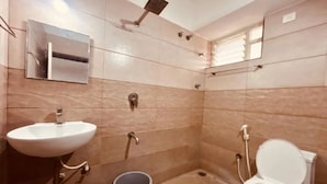 Un baño con lavamanos, inodoro y ducha.