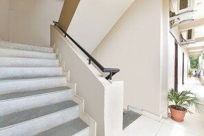 A staircase with a handrail, leading to an upper floor. - Fabhotel Jmd 11 (Indore)