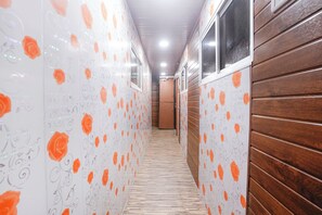 A narrow hallway with patterned wallpaper and wooden paneling. - Via Shiv Vandana Inn (Mumbai)