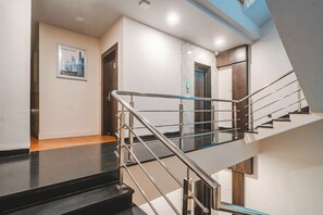 Ein modernes Interieur mit einer Treppe, einem gerahmten Bild an der Wand und einer Tür zu einem weiteren Raum.