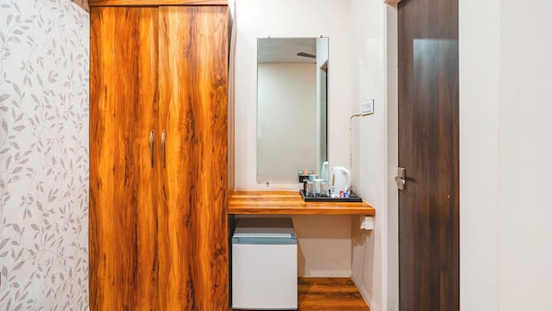 Habitación pequeña con armario, kitchenette y espejo.