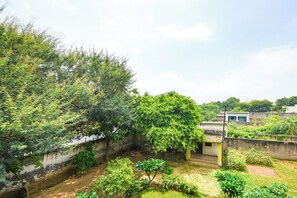 A residential area with a narrow water channel, greenery, and a small building with a flat roof. - Fabhotel Grg Bhawan (Vrindavan)