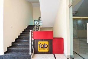 A hotel reception desk with a staircase leading to an upper floor. - Fabhotel Grg Bhawan (Vrindavan)