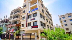 A multi-story hotel with a sign for 'The Fit Garage' and 'Banquet' services. - FabHotel Moubani Residency (Barasat)