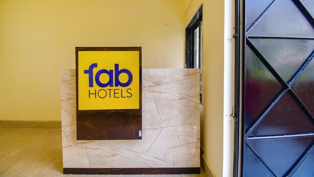 A reception desk with a sign for 'fab hotels' against a yellow wall. - FabHotel Moubani Residency (Barasat)