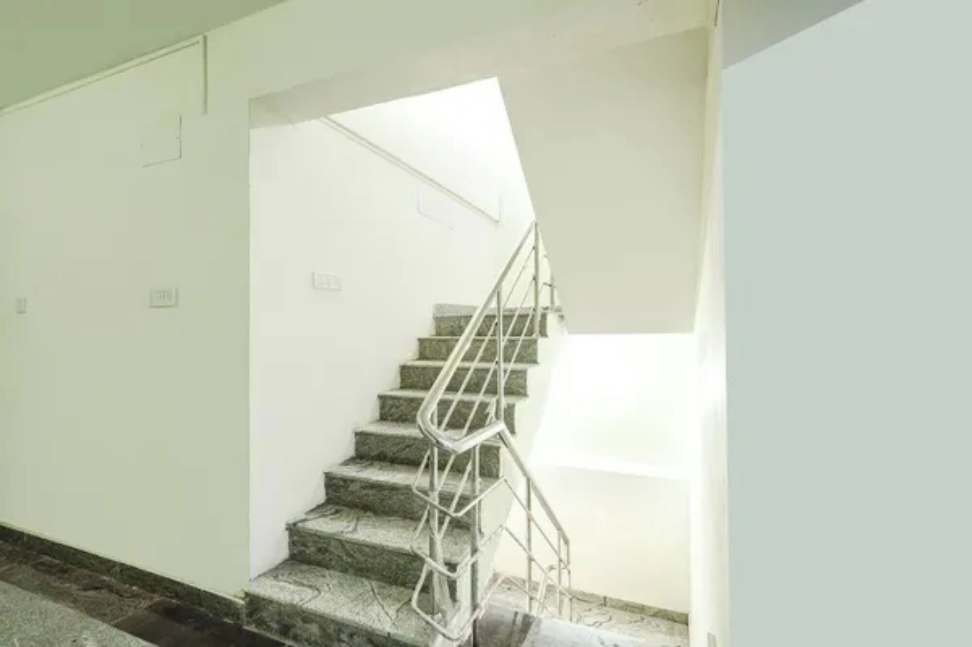 A staircase with a metal railing leading to a landing.