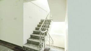 Een trap met een metalen leuning die uitkomt op een plateau.