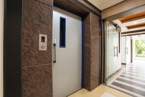 Hissi, jossa on digitaalinen näyttö, painike ja sinisellä kehyksellä varustetut ovet.