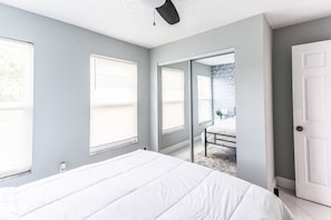 A bedroom with a bed, a door, and a window. - Oasis on the Shore of Lake Fort Myers (Fort Myers)
