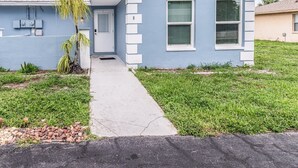A single-story house with a front door, a small porch, and a grassy yard. - Lakeside Oasis Fort Myers (Fort Myers)