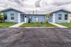 A two-story residential building with a flat roof, a front yard with a small garden, and a paved driveway. - Lakeside Oasis Fort Myers (Fort Myers)