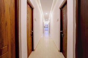 A hallway with wooden doors, a tiled floor, and a ceiling light.