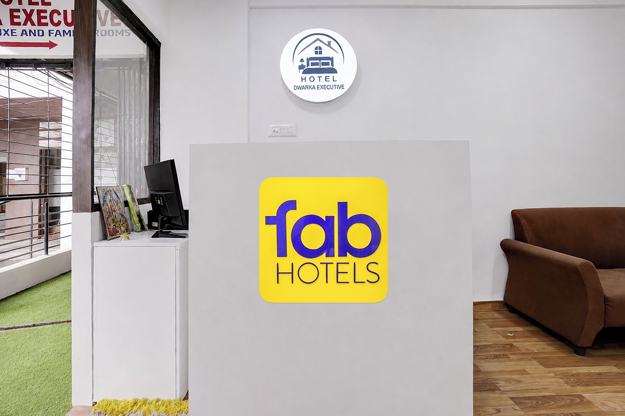 Una recepción con el logotipo de 'fab hotels' y un cartel que indica 'Hotel Dwarika Executive'.