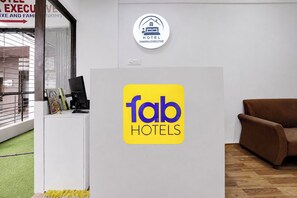 Vastaanottotiski, jossa on «fab hotels» -logon sisältävä kyltti ja «Hotel Dwarika Executive» -hotellin opastekyltti.