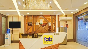 Ein Empfangsschalter mit dem Logo von 'Tab Hotels' und einer digitalen Uhr.