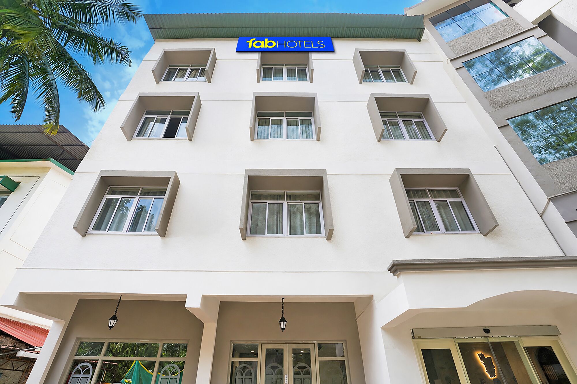 Un edificio de hotel de varios pisos con fachada plana, múltiples ventanas y un letrero que indica que es un establecimiento 'fab hotels'.