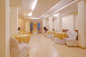 A hotel room with a large bed, a bedside table, and a window. - Oriva Solmar (Panaji)